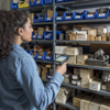 Lady counting stock with a scanner in stockroom