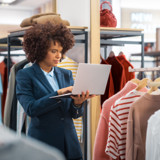 Fashion retailer using a laptop to manage product and supplier information