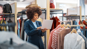 Fashion retailer using a laptop to manage product and supplier information